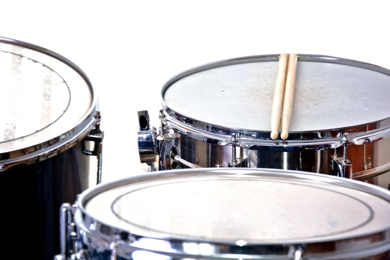 Drum_set_with_sticks Drums over isolated white background. Music conceptual image. Snare toms and cymbals.